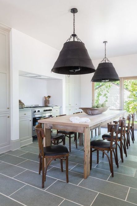 Large, industrial island pendants are featured above a table for ten. (Photography by Alyssa Rosenheck)