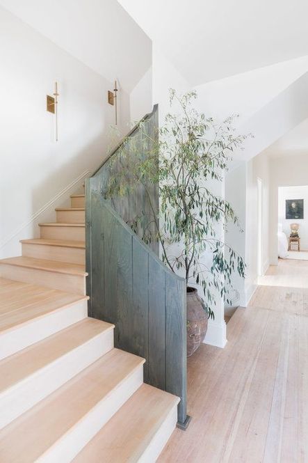 Vertical, fence-like railing frames a bleached wood staircase. (Photography by Alyssa Rosenheck)