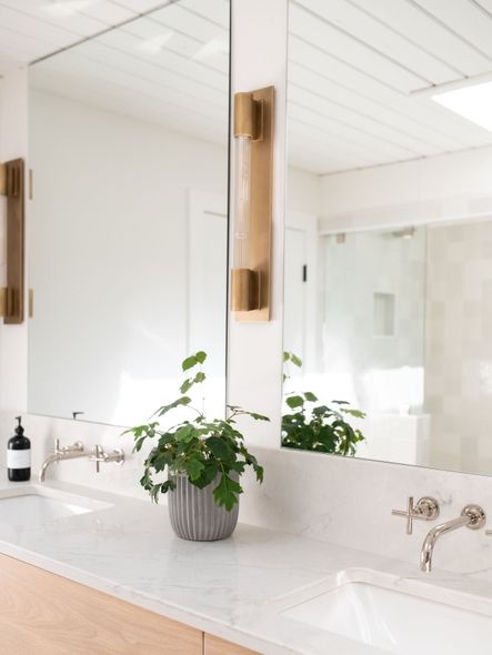 These eye-catching wall mounted faucets are modern, sleek, and the perfect accent to the brassy sconces above