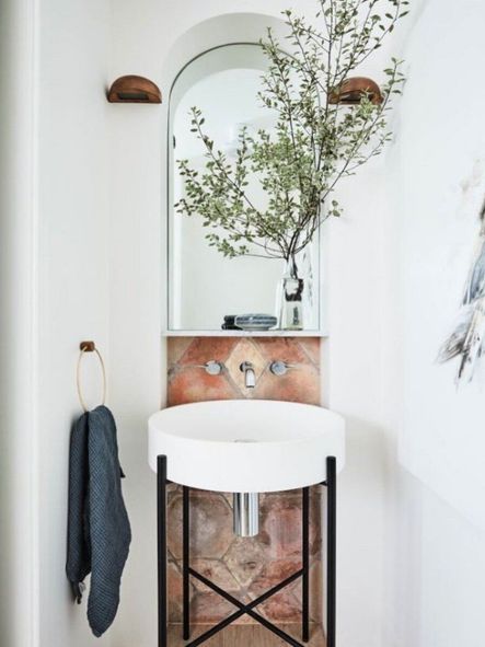 Also beneath the stairs sits a powder bathroom, which boasts an arched wall niche complete with tiling detail.
