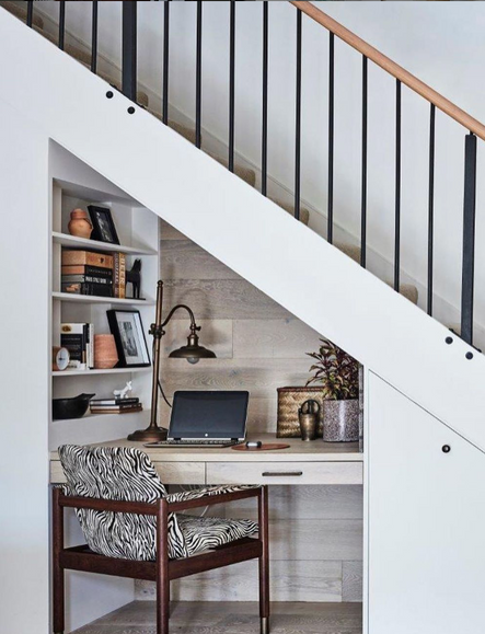 Space beneath the stairs is maximized with a small workspace, complete with niche shelving and a fun zebra-print chair! The cladded oak wall ties this hidden gem in with the rest of the main living area.
