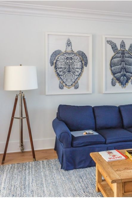 A tripod floor lamp and oversized turtle prints line the room.
