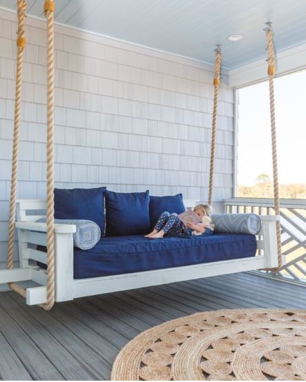 This outdoor space features a round jute jug and large suspended daybed, making it the perfect place to lounge on a lazy Sunday afternoon.