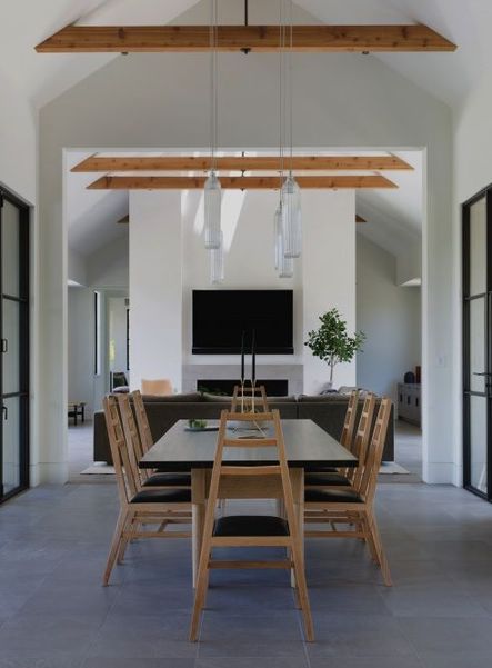 A-frames all the way | A second dining area in the home opens up to the living room, which also features a vaulted ceiling. These A-frame dining chairs seem to fit in perfectly!