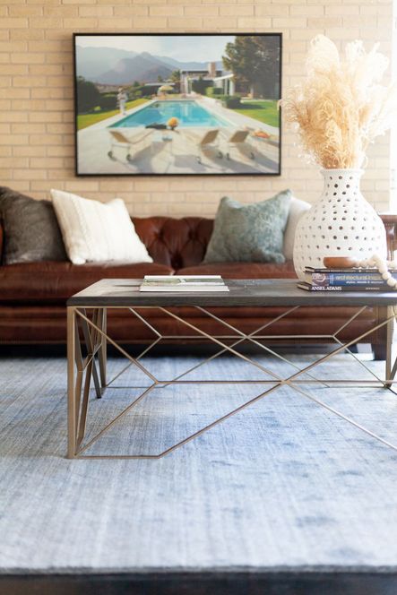 At the rooms center, clean lines & geometric shapes from the Theodore Coffee Table balance the natural textures from the porous vase and bone styling beads. The mixing of these modern and natural elements bring bring a sophisticated eclecticism into the space.
